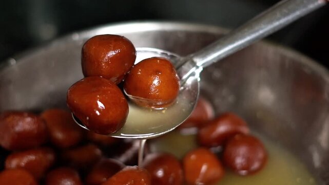Authentic Indian Sweet Gulab Jamun Preparation in a Professional Kitchen Environment. Freshly Cooked Gulab Jamun Mithai Texture for Diwali and Indian Wedding Catering.
