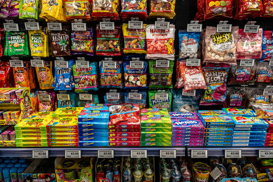 A colourful candy display at a store in Dublin, featuring shelves of Haribo, M&Ms, Nerds, and Sour Patch Kids with Euro price tags.