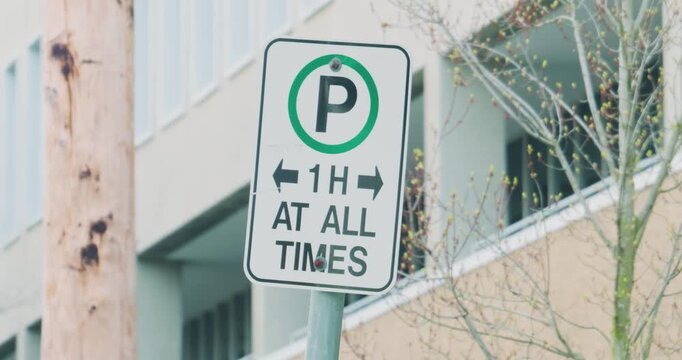 'Official green and white parking sign indicates a one-hour time limit for street-side vehicles