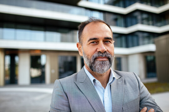 Portrait of confident bearded businessman outside modern office building