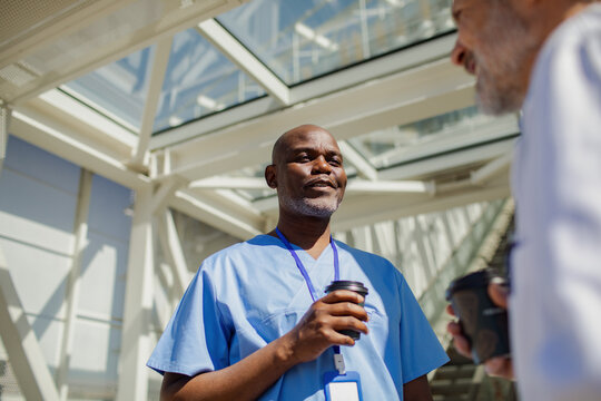 Healthcare worker having coffee in hospital atrium