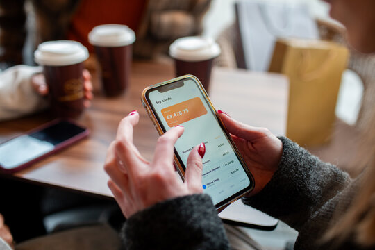 Person checking mobile banking balance at cafe table