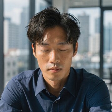 Stressed male professional taking a breath to refocus at office desk in urban environment