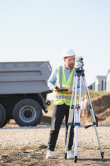 Naklejka premium Surveyor man working with digital tablet and total station