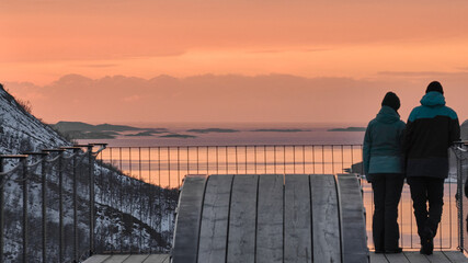 Fototapeta premium Couple Enjoys Sunset View Over Snowy Landscape in Norway