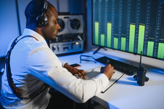 African american police officer records a telephone conversation on a tape recorder. secret agent