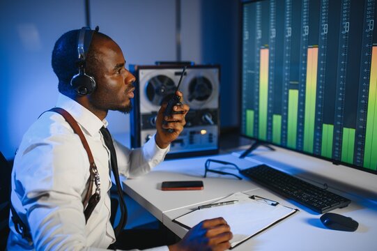 Secret agent listens on the reel tape recorder. Officer wiretapping in headphones