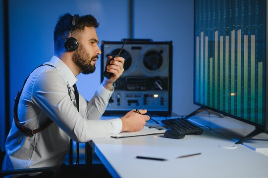 Secret agent listens on the reel tape recorder. Officer wiretapping in headphones