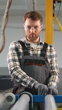 Factory worker supervising polyethylene pipe production line