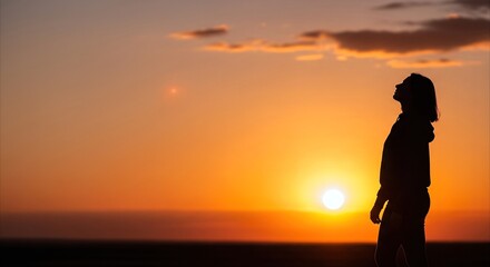 Obraz premium Silhouette of a woman looking up at a vibrant sunset, symbolizing hope, inspiration, and new beginnings with ample copy space