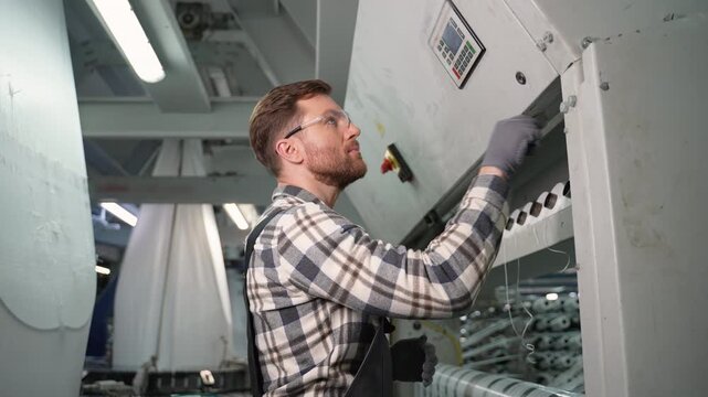 Factory worker operating industrial polypropylene weaving machine