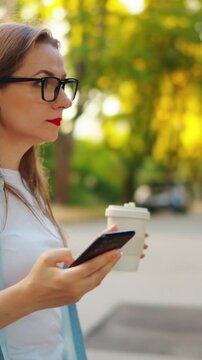 Woman with the smartphone is going through the neighbourhood.