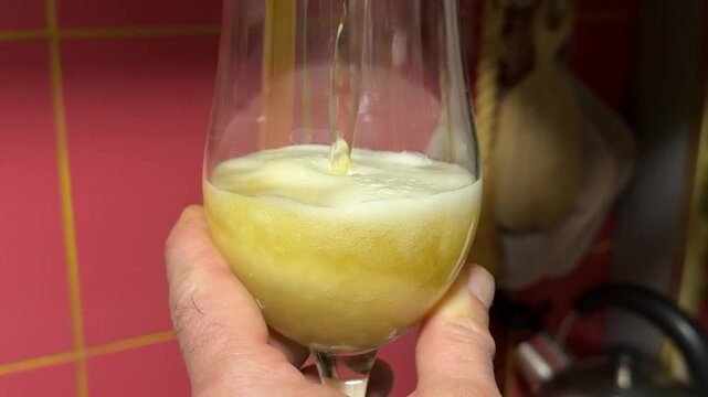 pour a glass of beer Chicken wings being mixed with beer marinade in a bowl for flavorful pre-cooking preparation in kitchen