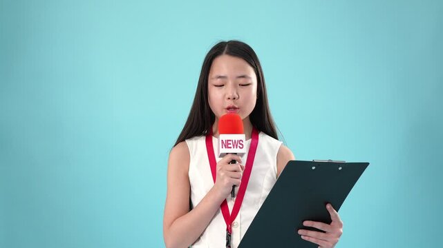 Young asian girl news reporter speaking with microphone and clipboard