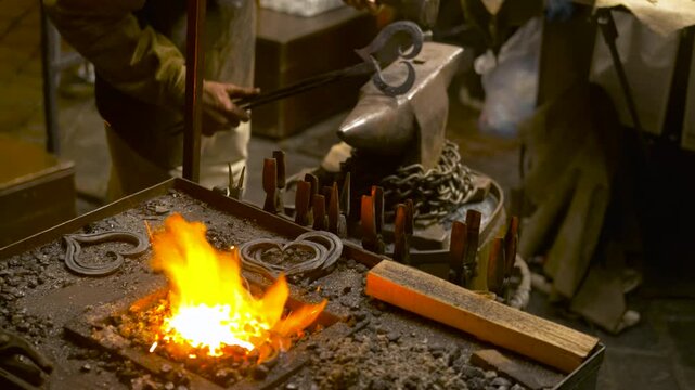 Blacksmith forging iron heart on anvil. Skilled blacksmith using a forge and anvil to craft a heart-shaped iron object, with flames and glowing hot metal showcasing traditional metalworking techniques