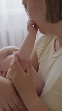 Gentle maternal bond. Calm morning moment with mother and infant peacefully interacting on bed. Mom engages with her baby through affectionate play. happy domestic motherhood routine in cozy home