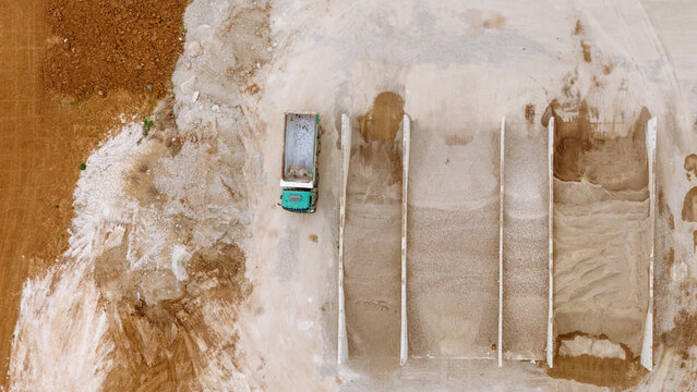 Aerial view of a dump truck parked next to gravel storage bays at an industrial site in Sabac, Vojvodina, Serbia.