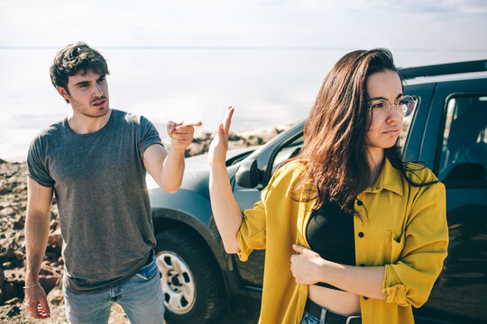 Family quarrel near the car. Scandal and disagreement concept. Crisis in the family. Husband screams at his wife. Couple wants a divorce.