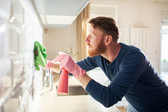 Adult man cleaning kitchen tiles at home