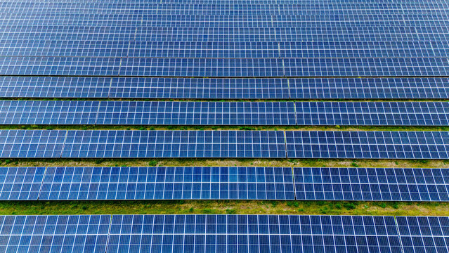 Aerial view of rows of blue solar panels in a large solar farm under bright daylight Sabac, Vojvodina, Serbia.