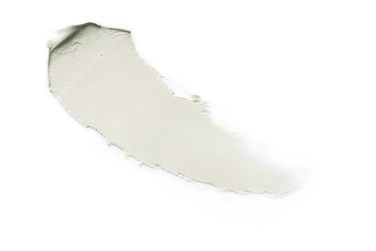 Curved light green cosmetic cream smear on white background.