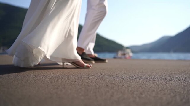 Bride strolling near ocean. Barefoot bride by tranquil shoreline