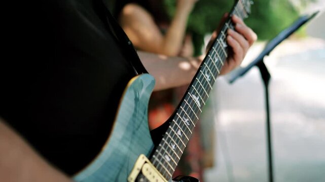 Relaxed singer and guitarist enjoying warm outdoor acoustic session