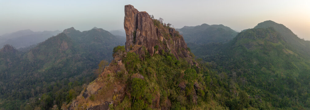 Aerial view of the iconic La Dent de Man rocky peak rising above lush green hills and dense tropical forests in Man, Montagnes District, Cote d'Ivoire.