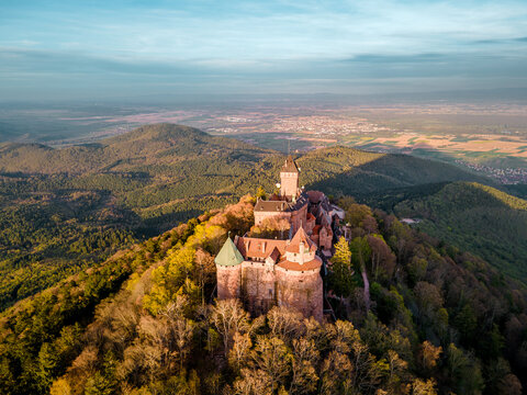 Castle Haut-Koenigsbourg, Alsace, France - April 10, 2026 - Warm sunset lighting over medieval castle, terracotta walls bathed in amber glow, sweeping forest, lensready skyline, ideal for wedding