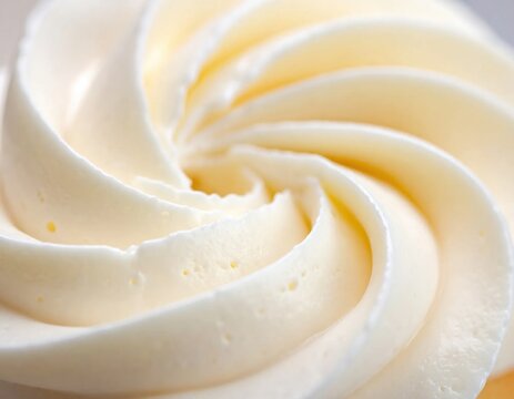 Close up view of creamy vanilla frosting swirled into a tight spiral texture, showing soft peaks and delicious icing patterns for dessert