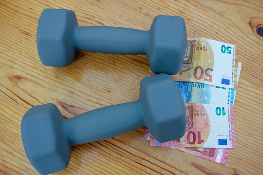 Grey 4kg dumbbells on Euro currency notes close-up