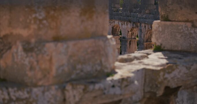 Blurred stone foreground framing the arches inside the ancient Pula Arena Roman amphitheater in Pula Croatia.