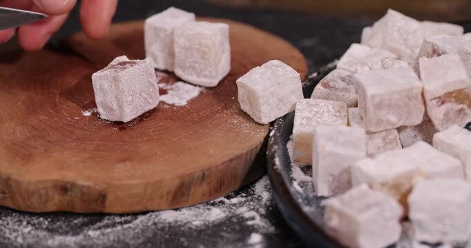 soft and fresh Turkish delight with powdered white sugar, cubic sweet white soft pieces of Turkish delight with nuts and dried fruits inside, closeup