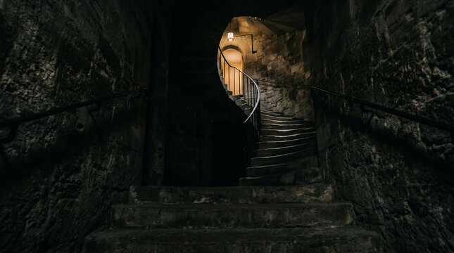 Journey into the Cavern: An atmospheric stone staircase leads downwards into the depths, illuminated by a warm light that beckons the viewer onwards, creating a sense of mystery.