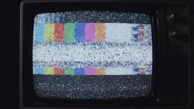 A vintage television displays static and colorful test patterns, evoking a sense of nostalgia and technological obsolescence.