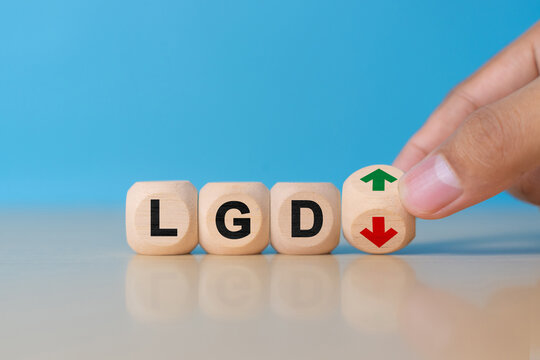 Loss given default or LGD business acronym concept with wooden cubes and downward arrow symbol