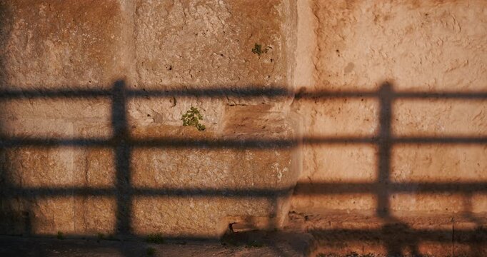 Close view of a weathered stone wall with shadow patterns on the exterior of the ancient Pula Arena Roman amphitheater in Pula Croatia.