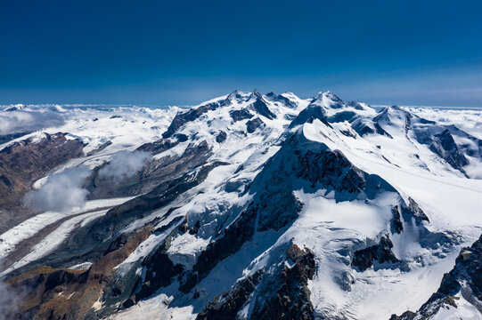 Aerial Drone View of Monte Rosa Massif with Multiple Snowy Peaks and Glaciers | Zermatt Swiss Alps Above Clouds | High Altitude Mountain Panorama
