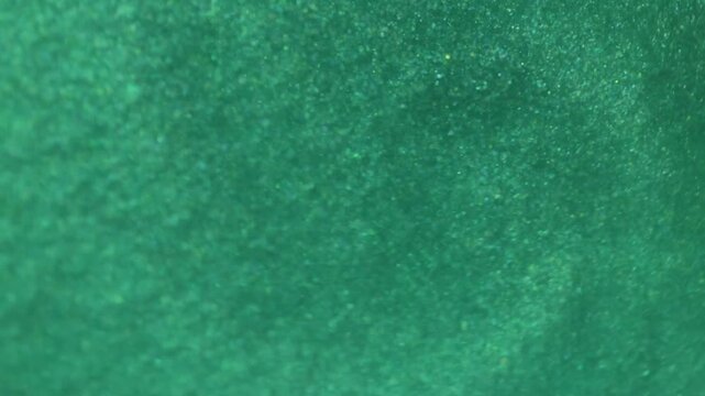 sparkling iridescent liquid texture glitter shine in emerald and green tones.beauty shimmering,iridescent liquid background