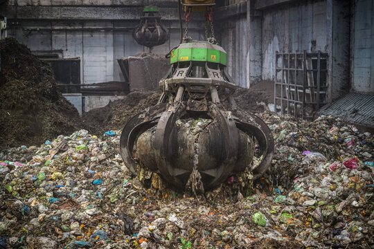 View of a mechanical grapple claw lifting organic waste at the Forsu Iren treatment plant in Reggio nell'Emilia, Emilia-Romagna, Italy.