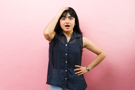 Young woman realizing her big mistake, feeling surprised and forgetful with hand on head