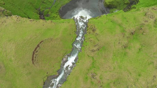 Aerial flight over the famous Seljalandsfoss waterfall on a summer day in Iceland. Top down view.