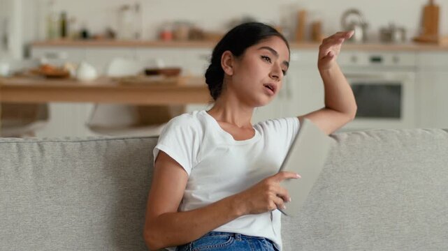 Overheated Indian Arabian woman at home waving notebook tired female sweating indoor suffering high temperature hot broken air conditioner lack of climate control discomfort studying girl heat problem