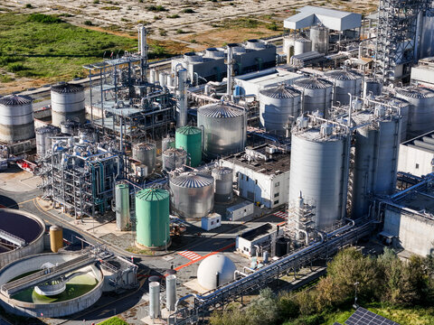 Aerial view of the Impianto chimico chemical plant featuring industrial storage tanks, complex piping systems, and processing units in Crescentino, Piedmont, Italy.