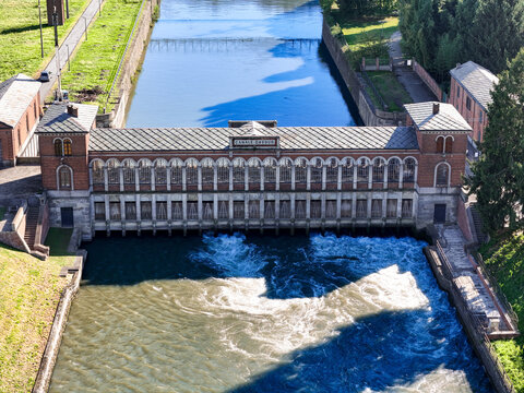 Aerial view of the historic Canale Cavour intake building with rushing water and arched windows Chivasso, Piedmont, Italy.
