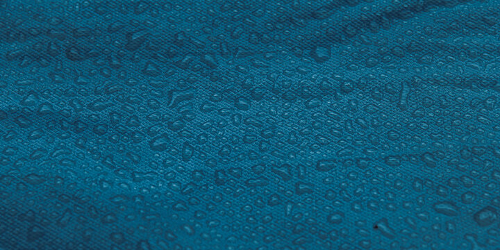 Water Droplets on Blue Waterproof Synthetic Fabric Surface