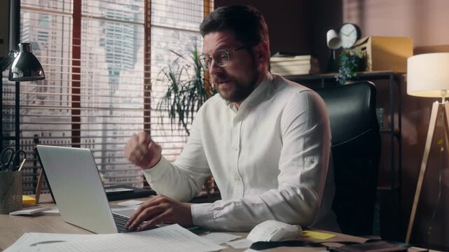 Stressed Caucasian business man working laptop in office feeling exhausted tired male yawning drinking coffee at desk online businessman employee overload burnout fatigue deadline low energy workplace
