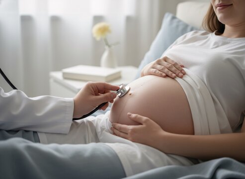 Pregnant woman lying on bed with doctor checking babys heartbeat
