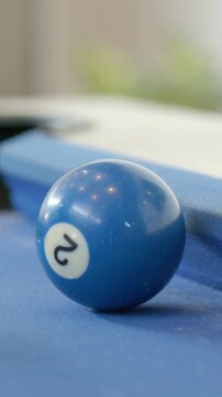 Vertical video: Rolling blue 2 ball colliding with red ball, guiding yellow ball into pool corner