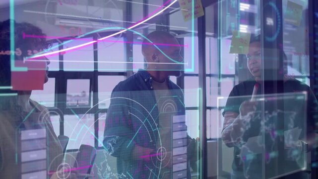 Team behind glass right lead pointing at projected charts, sparking notes prioritizing for business